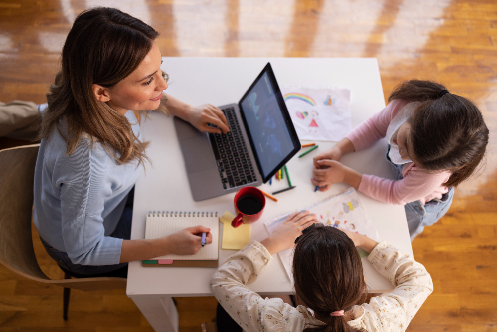 Tendencias pedagógicas: pedagoga sentada em frente a um notebook e na mesma mesa possui duas crianças ao seu redor.