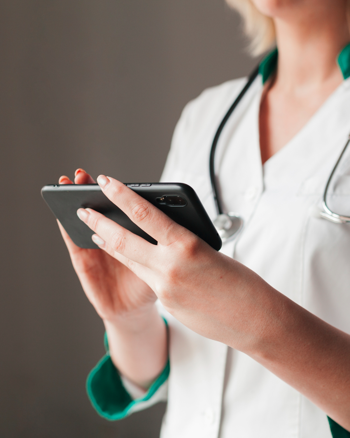Estudante da área da saúde segurando um celular enquanto utiliza aplicativos para estudar Medicina