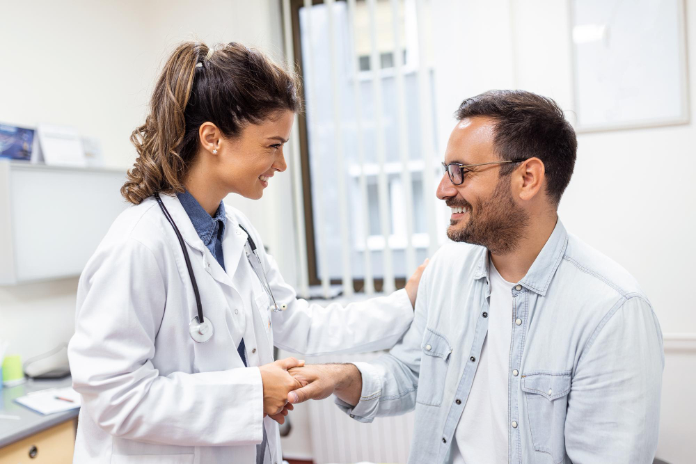 Médica em um consultório, segurando a mão do paciente e aplicando a medicina humanizada