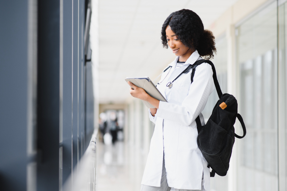 Estudante de medicina com uma mochila nas costas, no corredor de um hospital durante o internato.