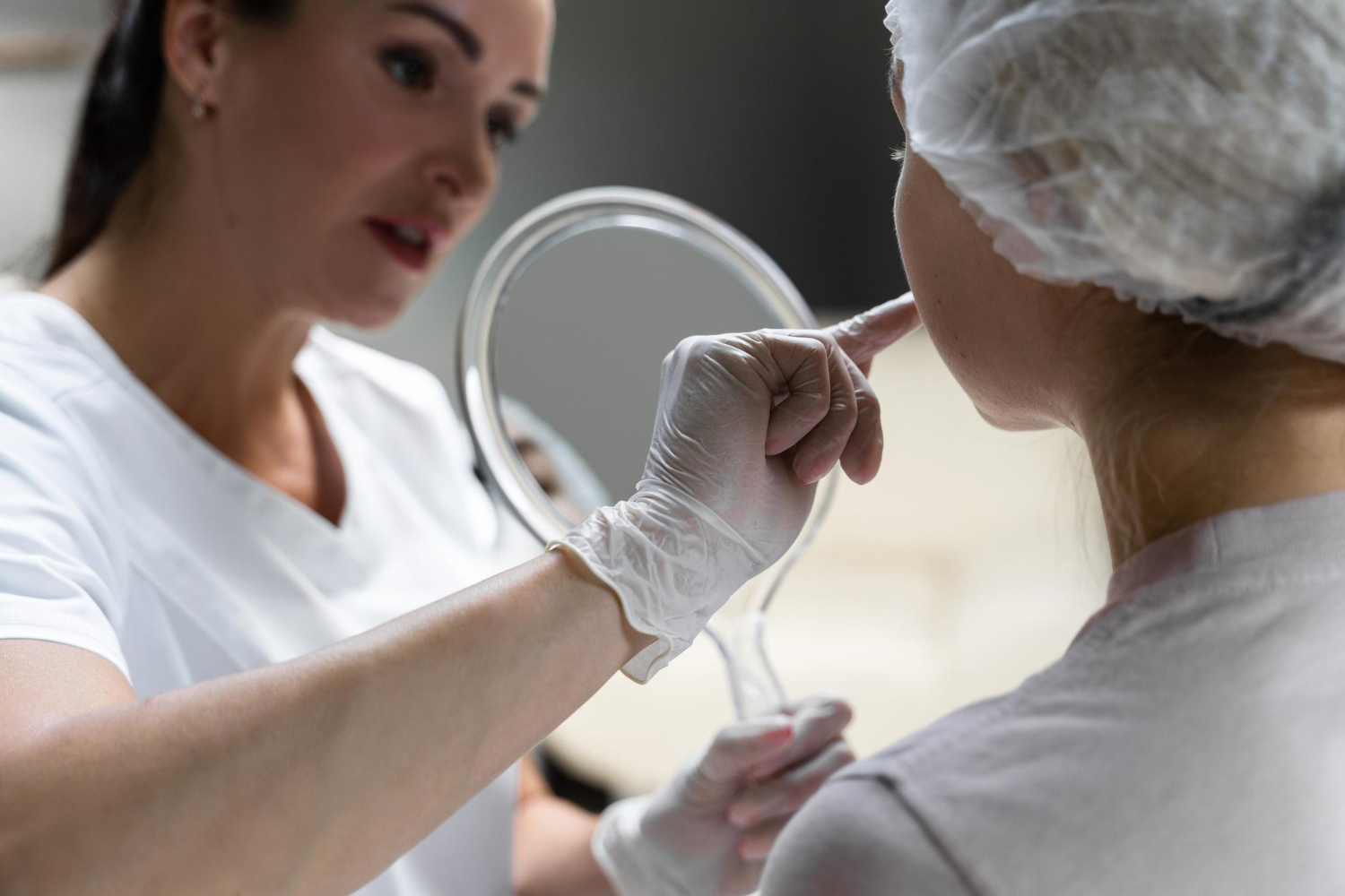 Dermatologista examinando o rosto de uma paciente.