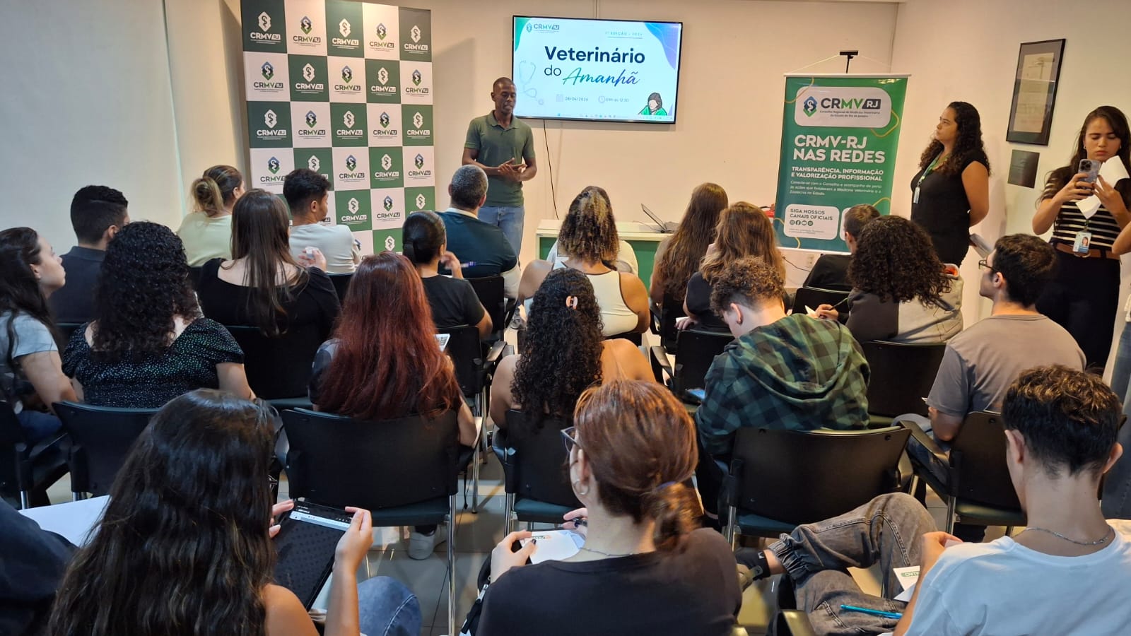 Participantes da ação promovida pela CRMV-RJ e um auditório durante evento