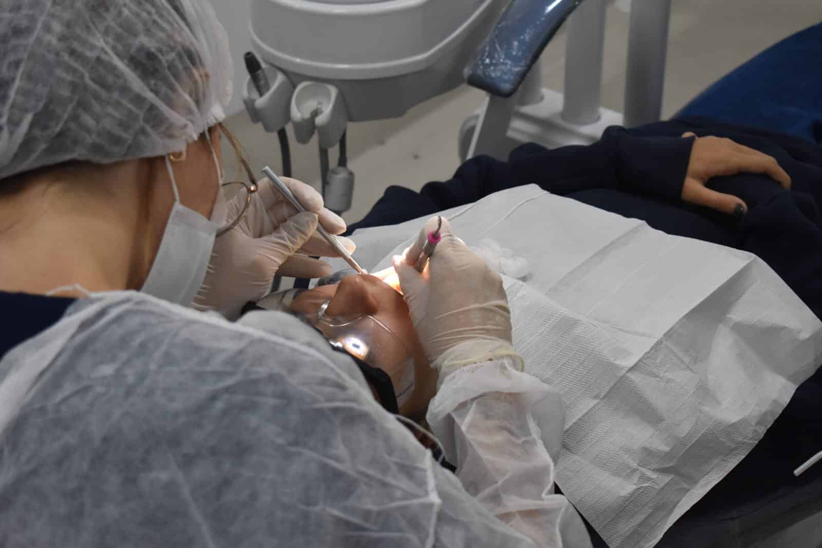 Atendimento odontológico durante campanha Maio Vermelho de prevenção ao câncer de boca em clínica universitária