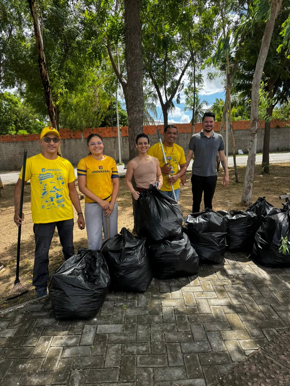 Colaboradores participam de ação de sustentabilidade com coleta de resíduos em área pública, reforçando o compromisso com a preservação ambiental.