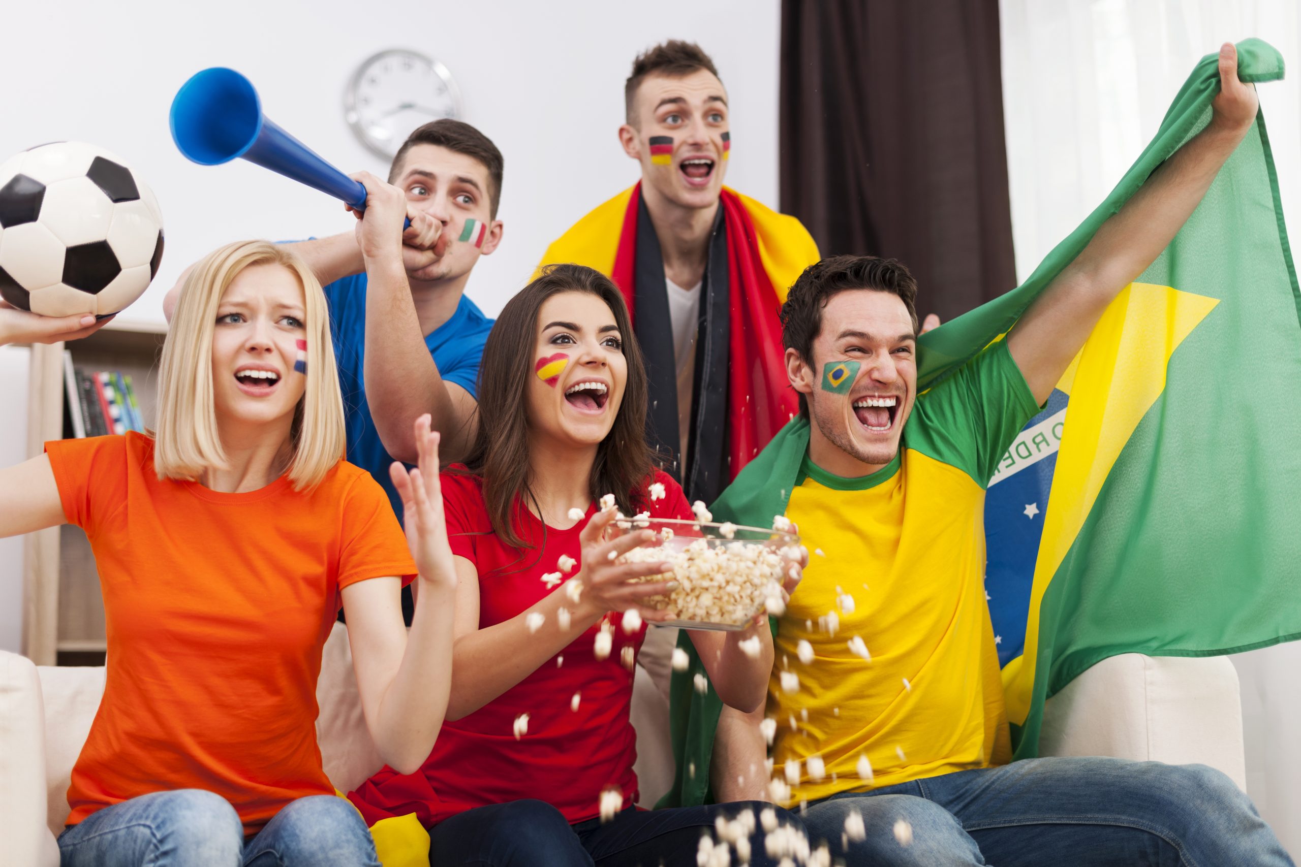 torcedores em uma casa assistindo a uma partida de futebol, representando a saúde mental durante a Copa do Mundo